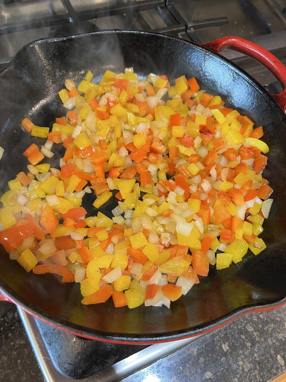 peppers and onions cooking in pan