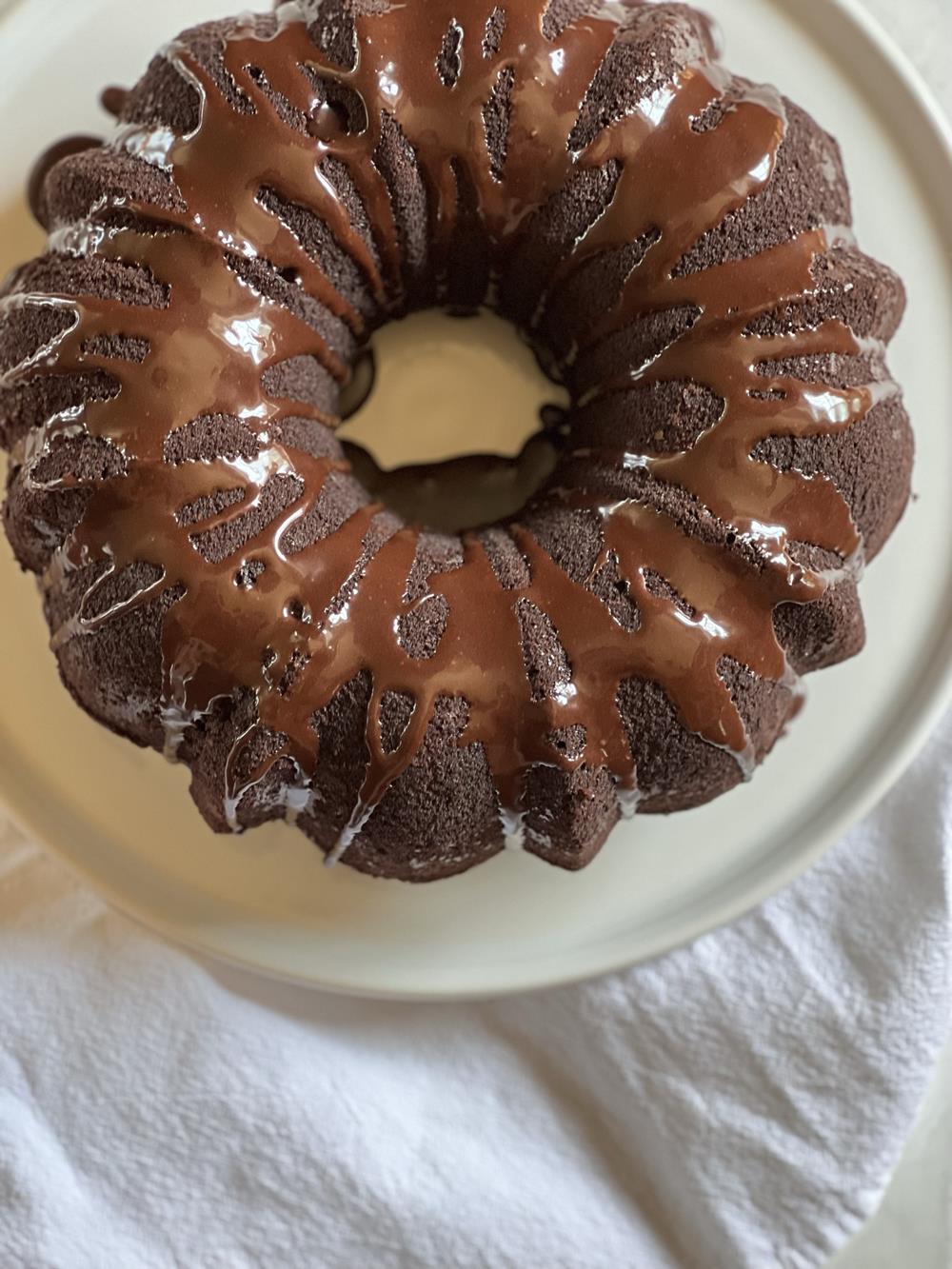 Gluten Free Chocolate Zucchini Bundt Cake with Chocolate Chips on white plate on white napkin