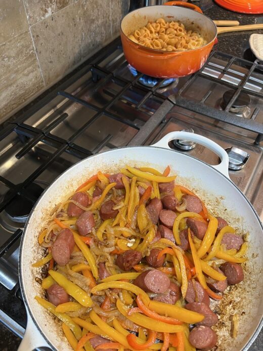 peppers and sausage cooking in a pan