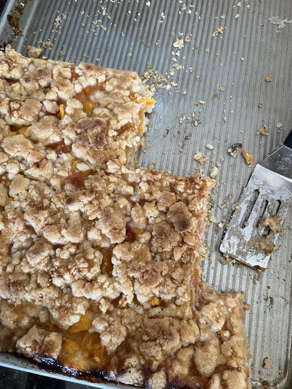 peach pie bars in pan with metal scoop