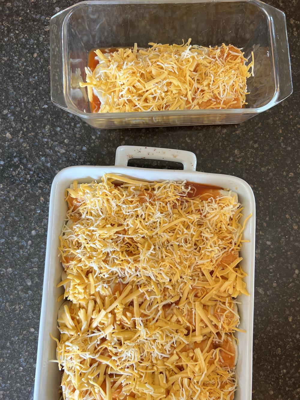 enchiladas in two pans one glass and one white