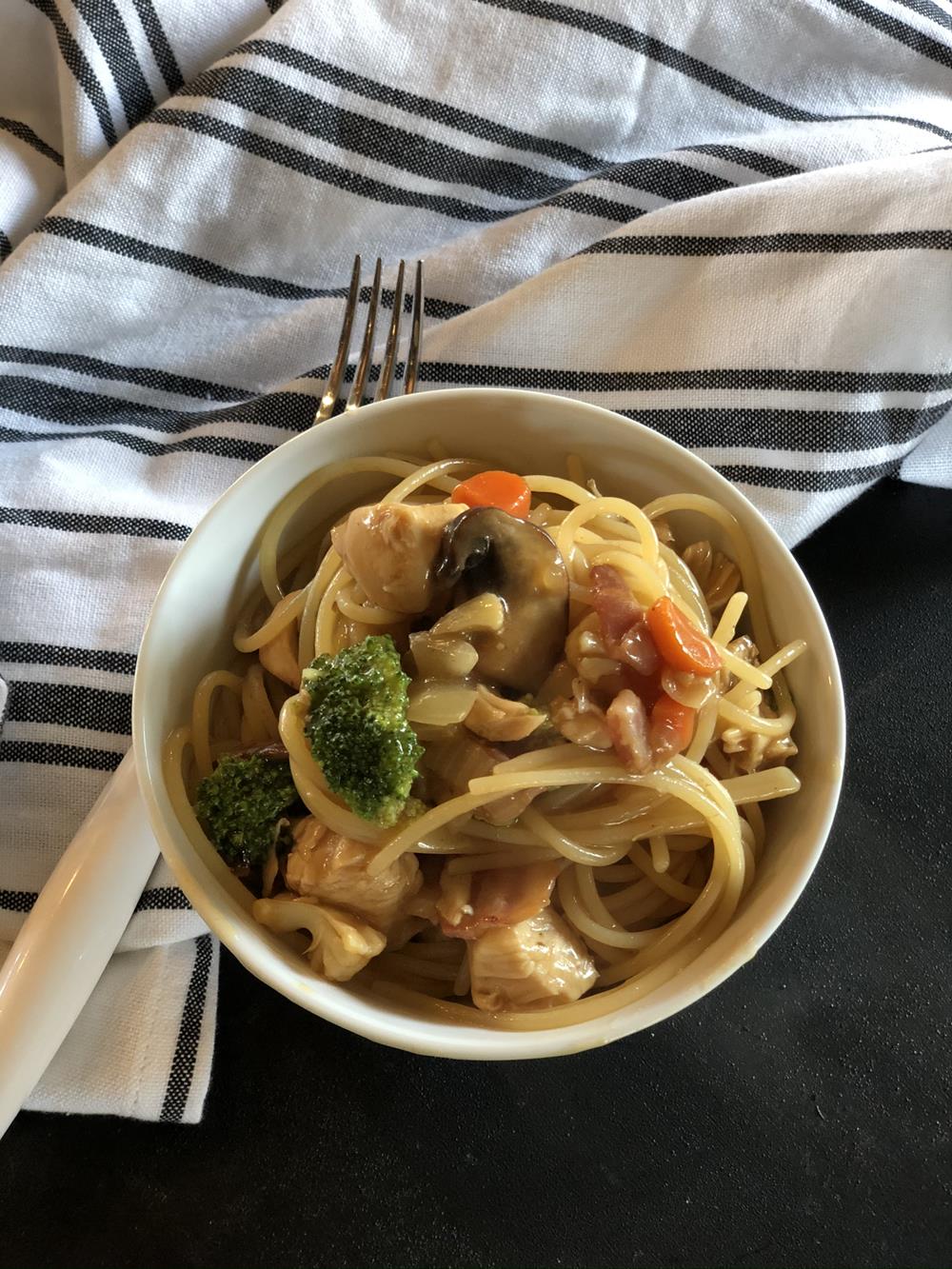 chicken bacon lo mein in white bowl