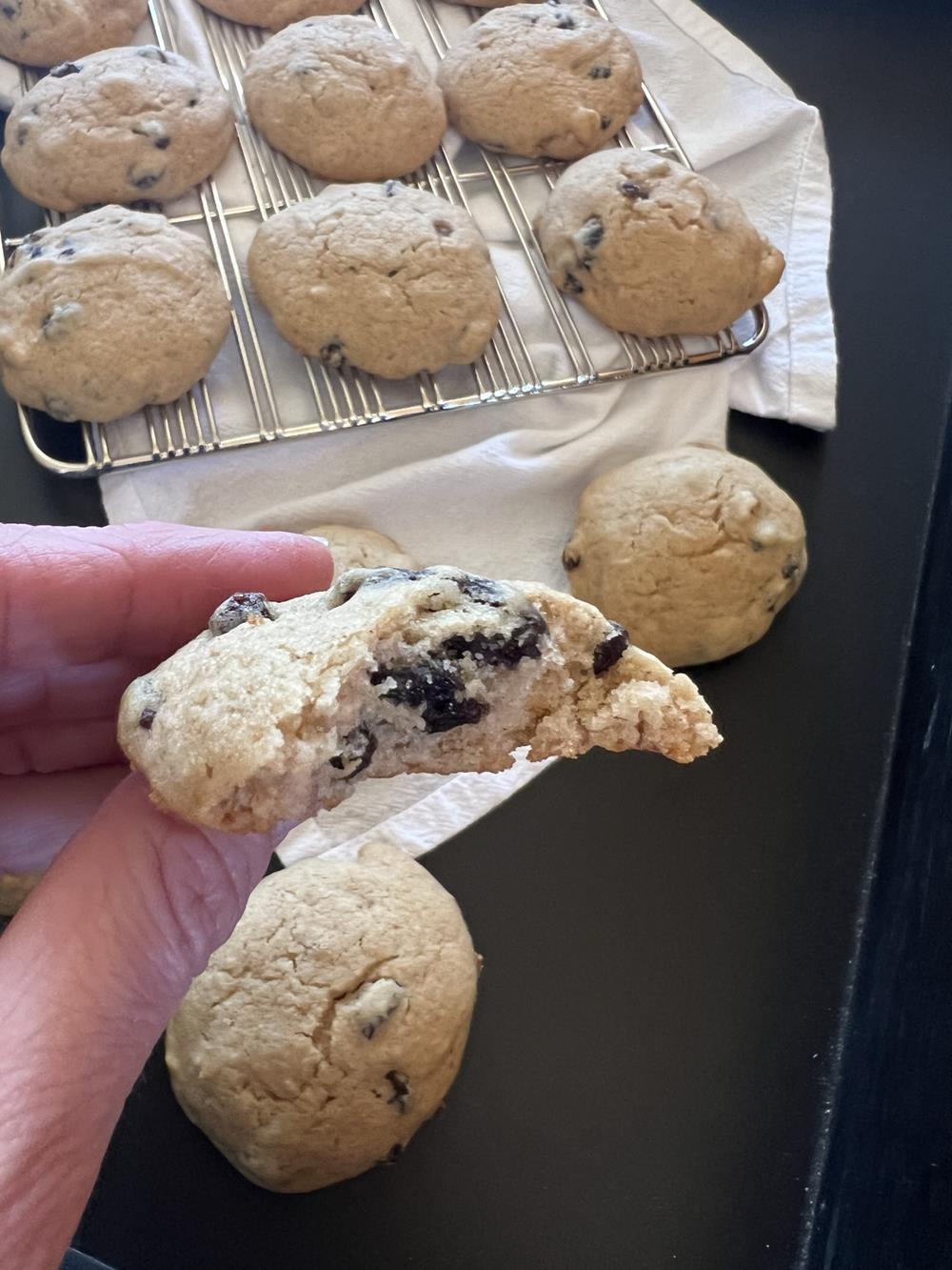 hand holding applesauce cookies with black background