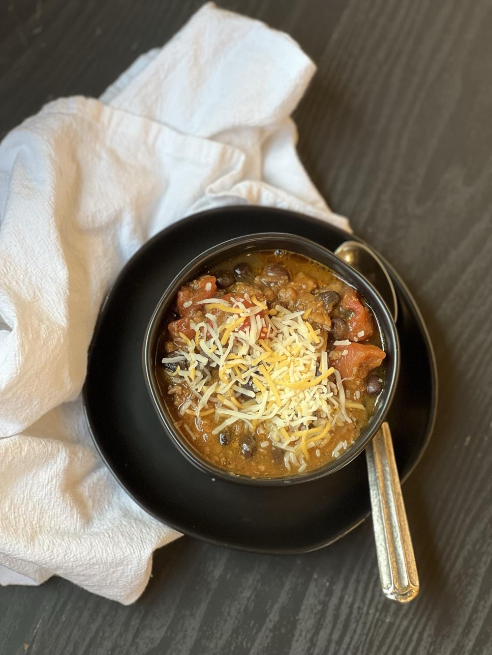 Slow Cooked Pumpkin Chili Recipe in black bowl on white napkin