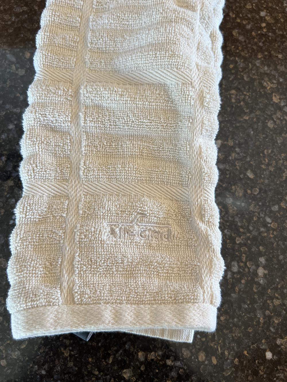 Tan all clad brand kitchen towel on counter