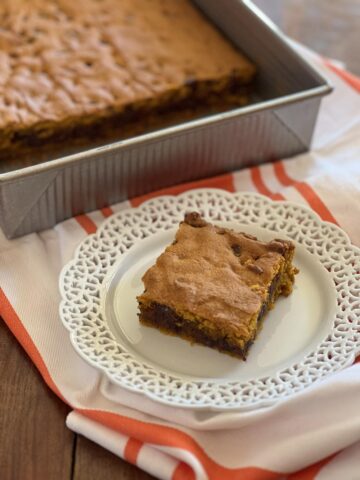 Chocolate Chip Pumpkin Bars on white plate on white and orange towel