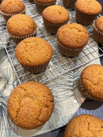gluten free pumpkin muffins on cooling rack with napkin in background