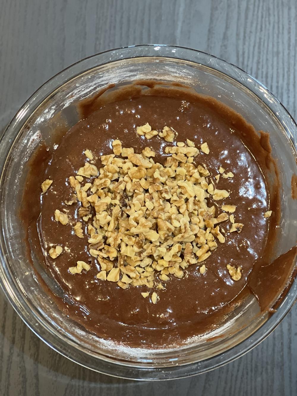 brownie batter with nuts in glass bowl