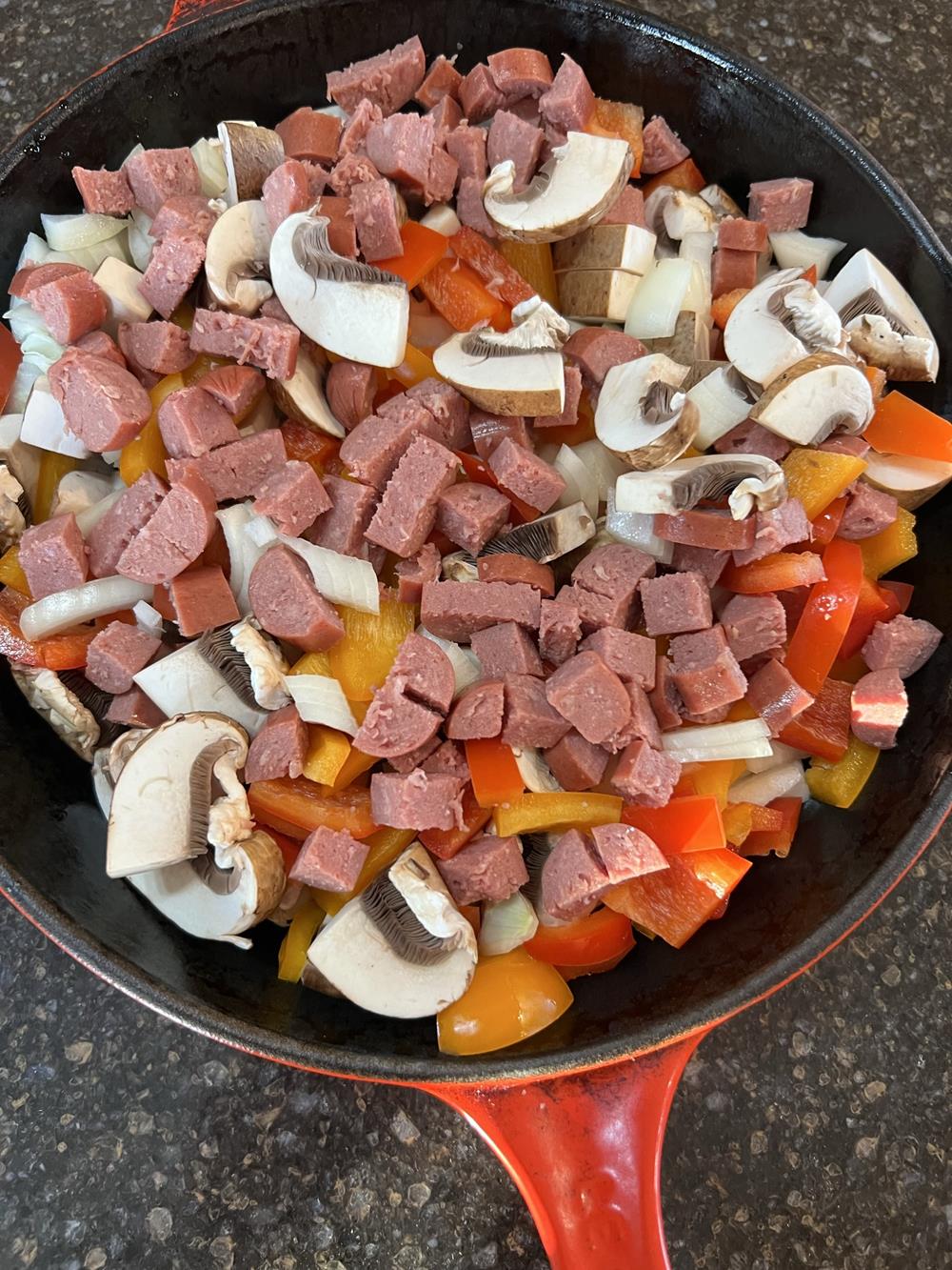 uncooked vegetables and meat in cast iron pan