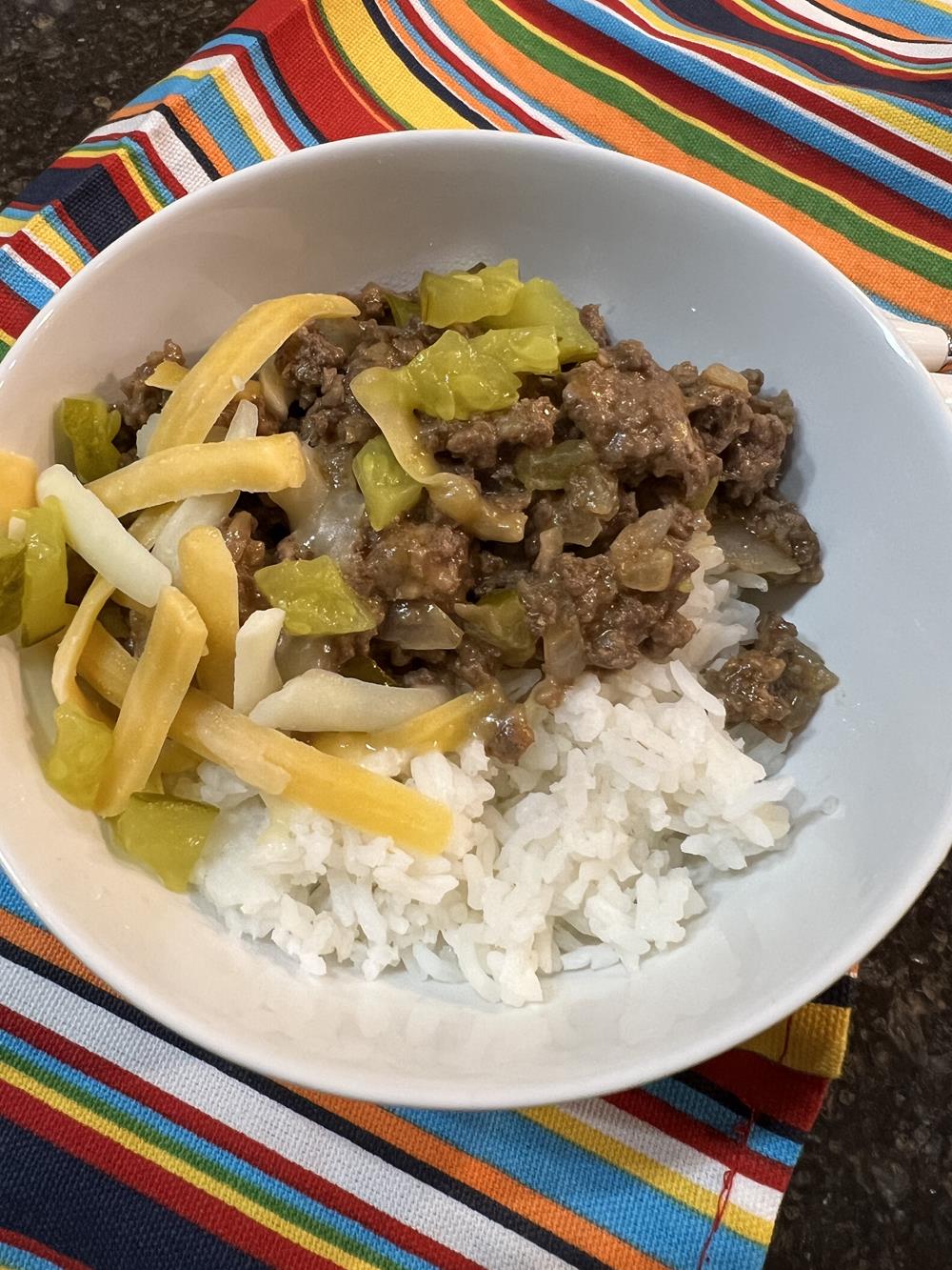 cheeseburger bowls rice ground beef pickles and cheese in white bowl on striped napkin