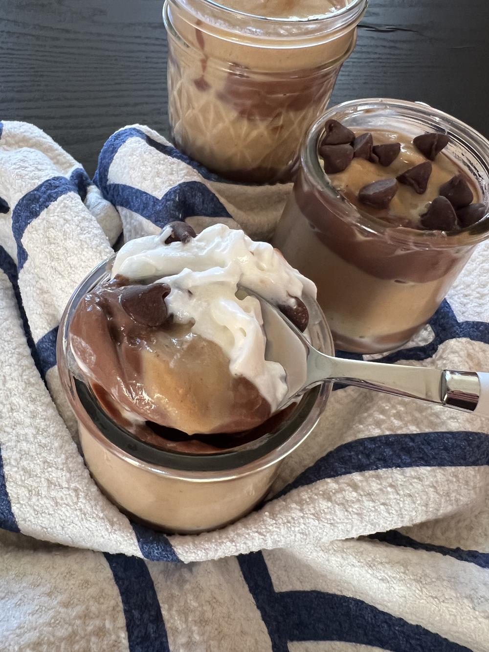 peanut butter and chocolate pudding in a glass bowl with spoon