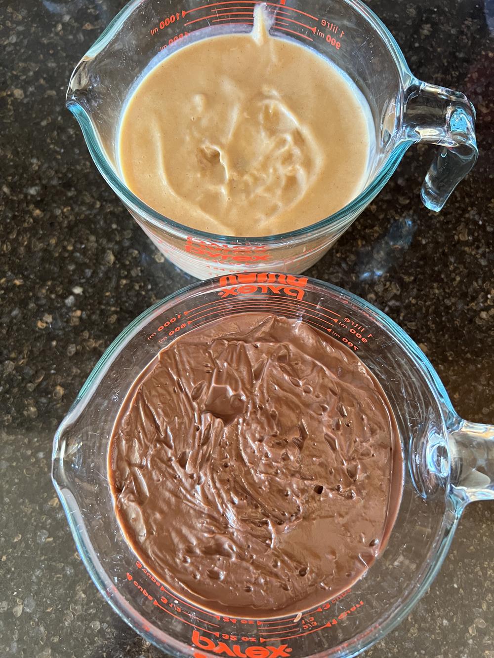 peanut butter pudding and chocolate pudding in glass measuring cups
