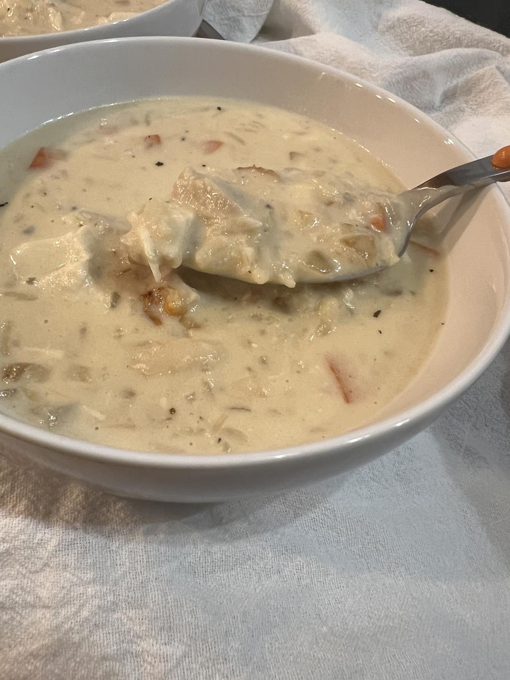 chicken and rice soup with spoon in a white bowl