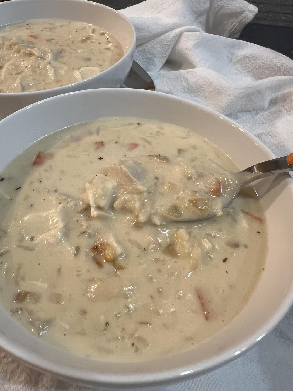 chicken soup with rice and carrots in white bowl