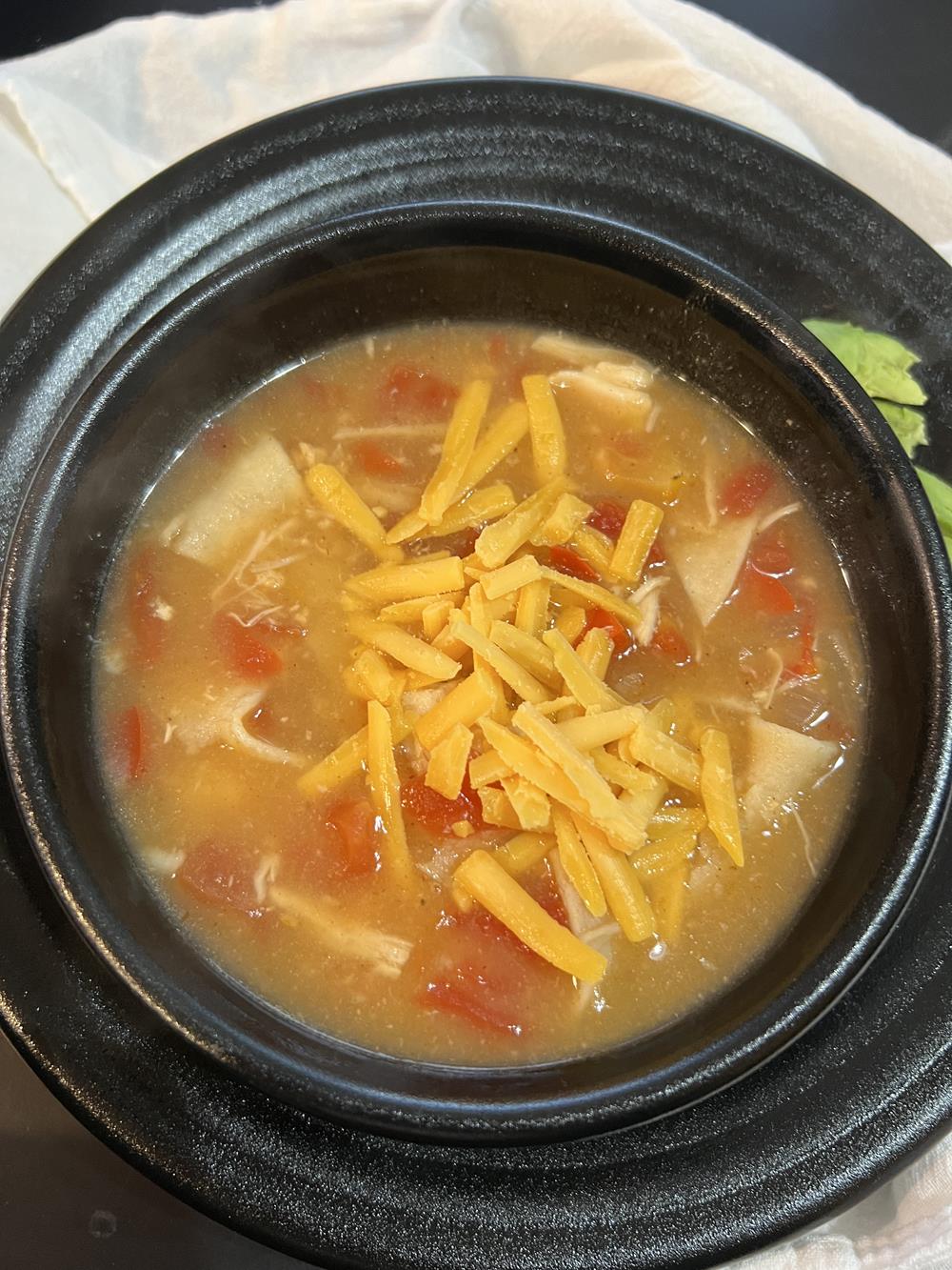 chicken tortilla soup in black bowl