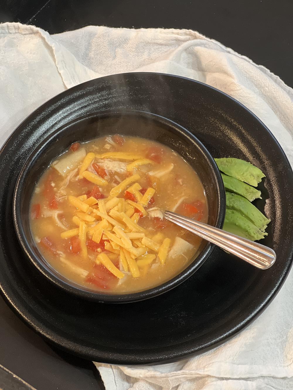 king ranch chicken soup in black bowl with spoon on white background