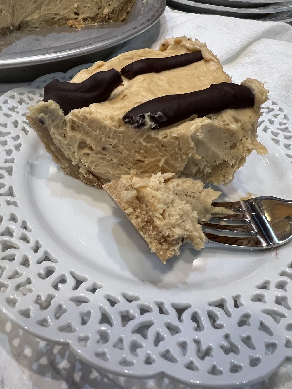peanut butter pie with peanut butter cookie crust on white plate with fork
