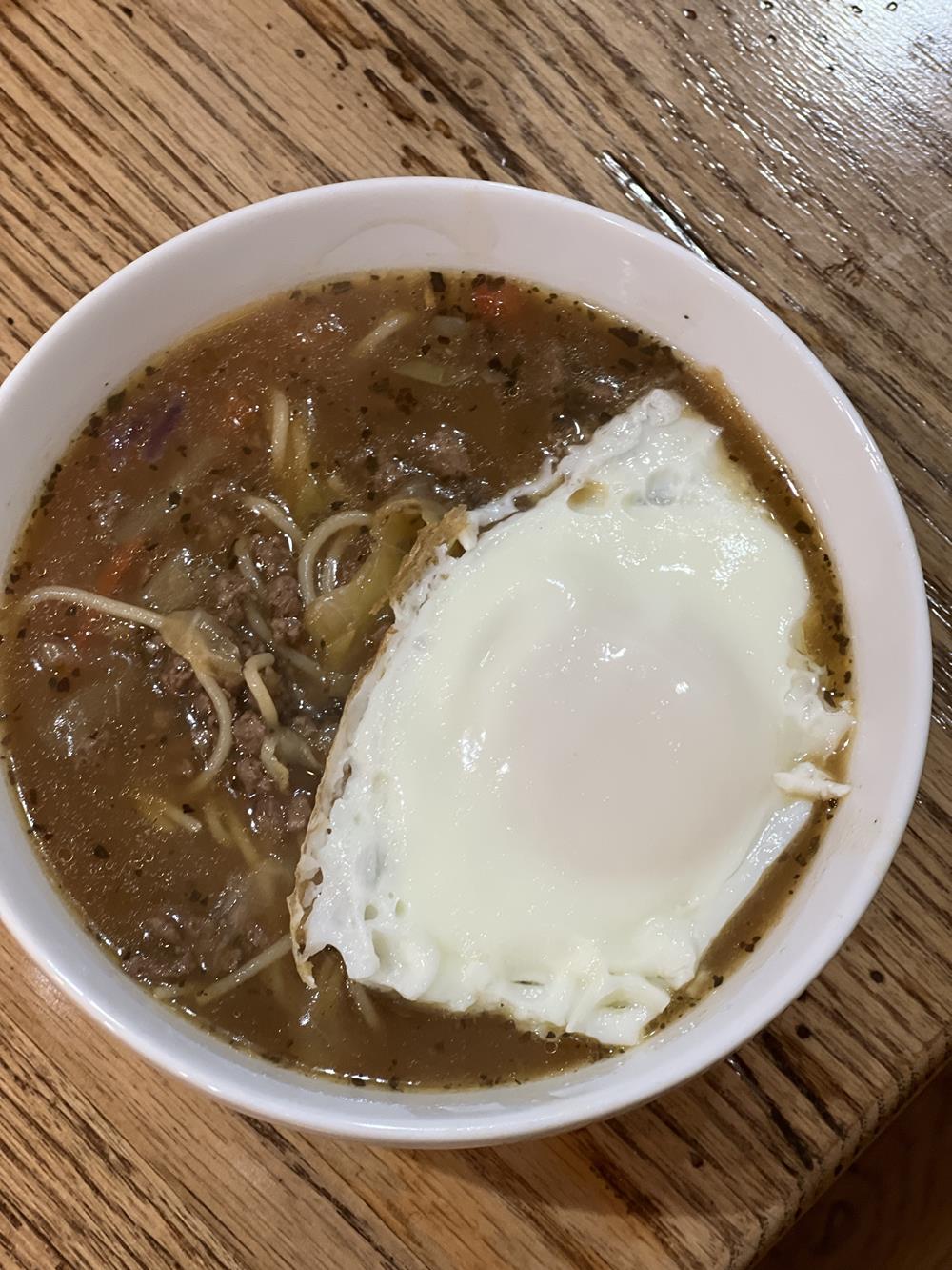 asian soup with egg in white bowl