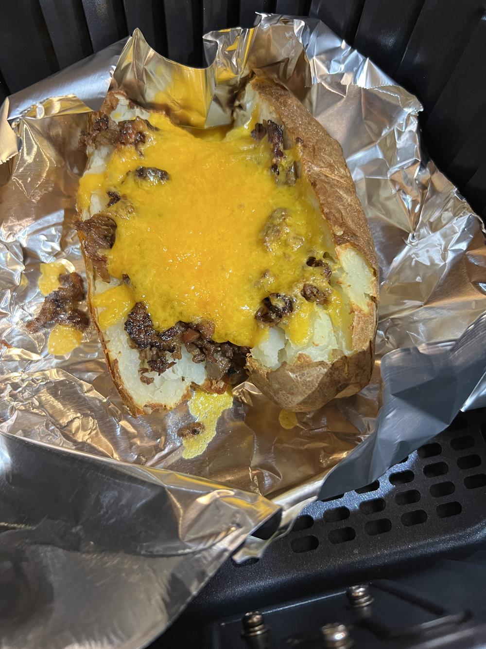 baked potato with cheese and bbq meat on top
