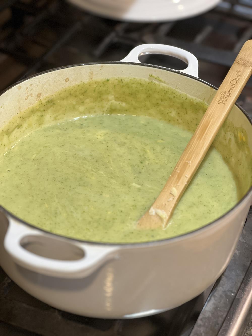 broccoli soup in white pot on stove with spoon