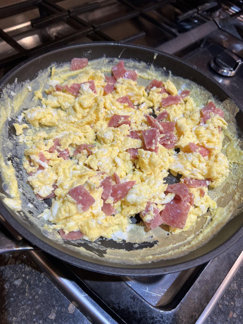 eggs and pepperoni in pan on stove