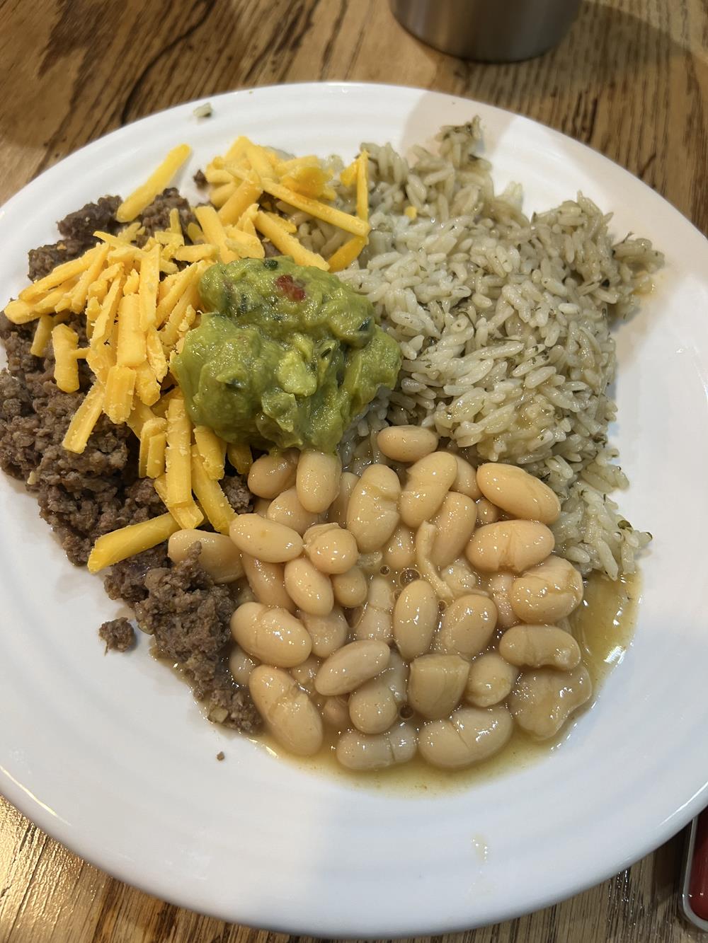 beans meat cheese rice on white plate