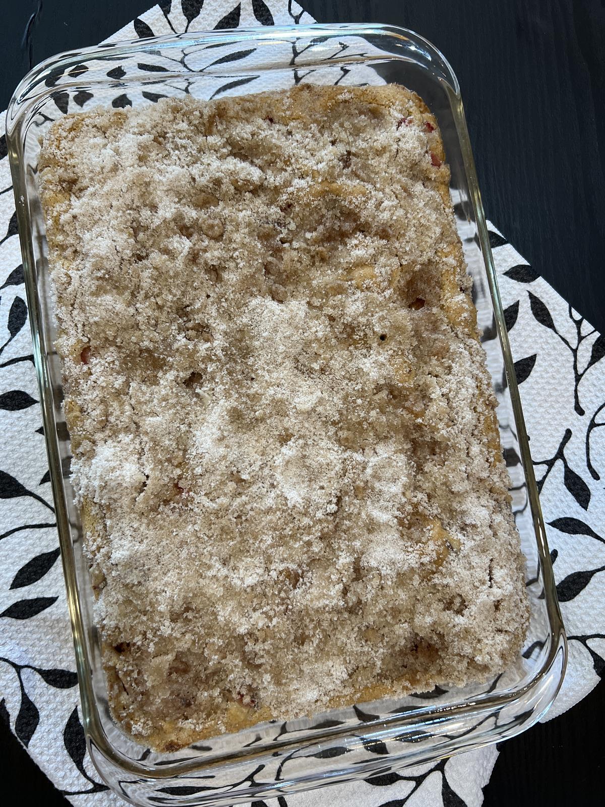 rhubarb cake in glass pan on black and white towel