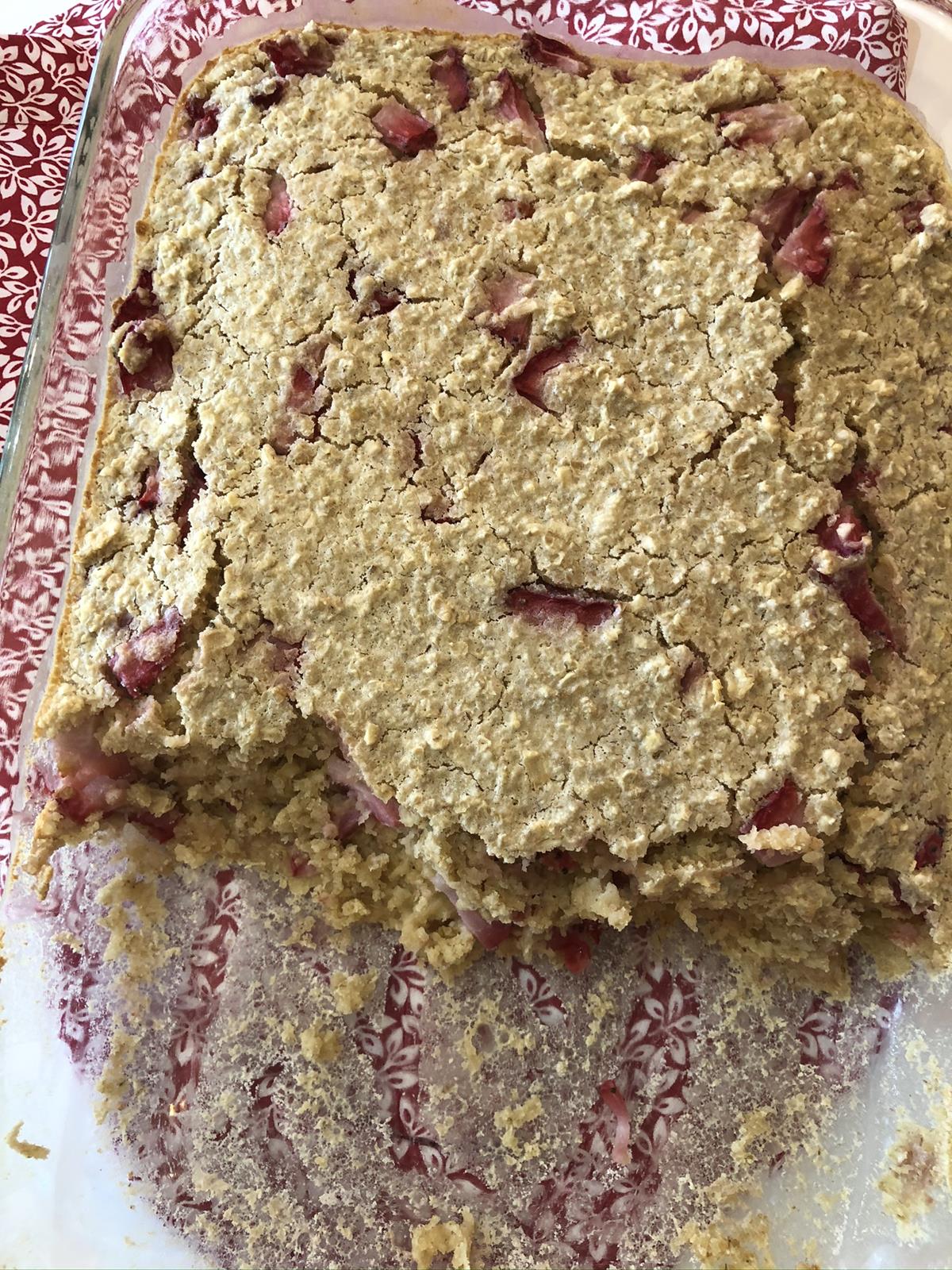 Strawberries and Cream Baked Oatmeal in glass dish on red and white flowered napkin