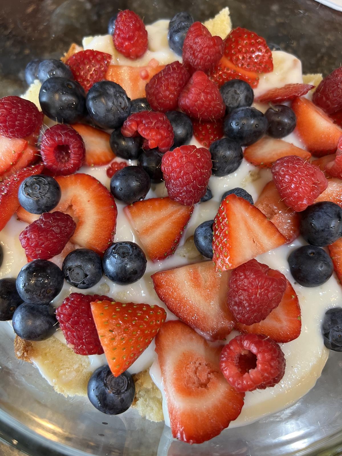 berries cool whip and pound cake in glass trifle bowl