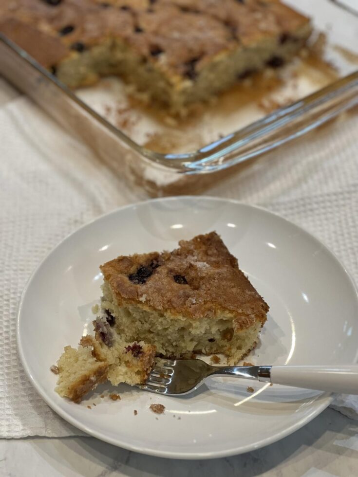 piece of gluten free blueberry coffee cake on white plate with white fork