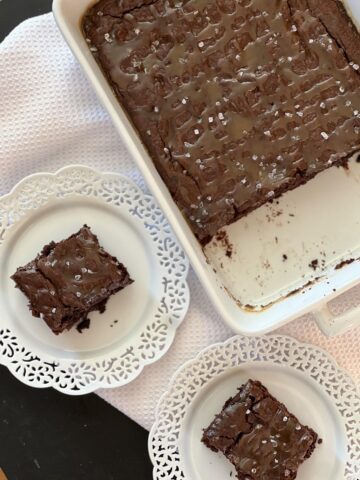 salted caramel brownies in white pan and two white plates