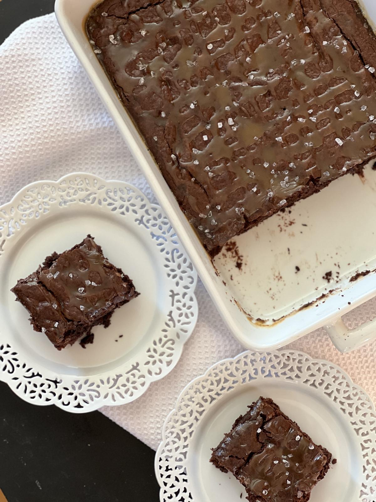 salted caramel brownies in white pan and two white plates