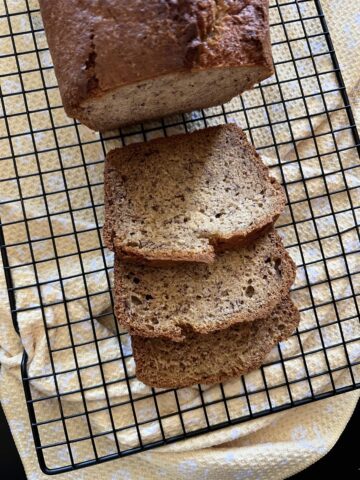 cooling rack with banana bread on yellow napkin