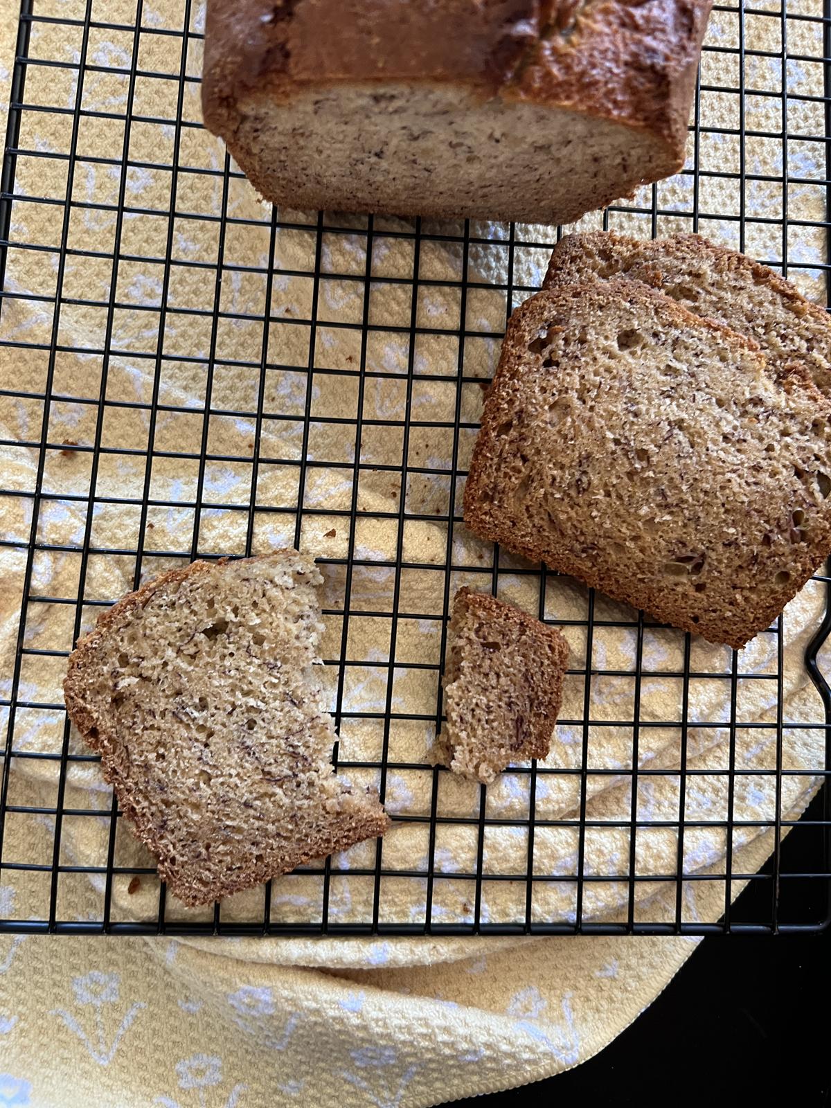 slices of dairy free banana bread on cooling rack with yellow napkin