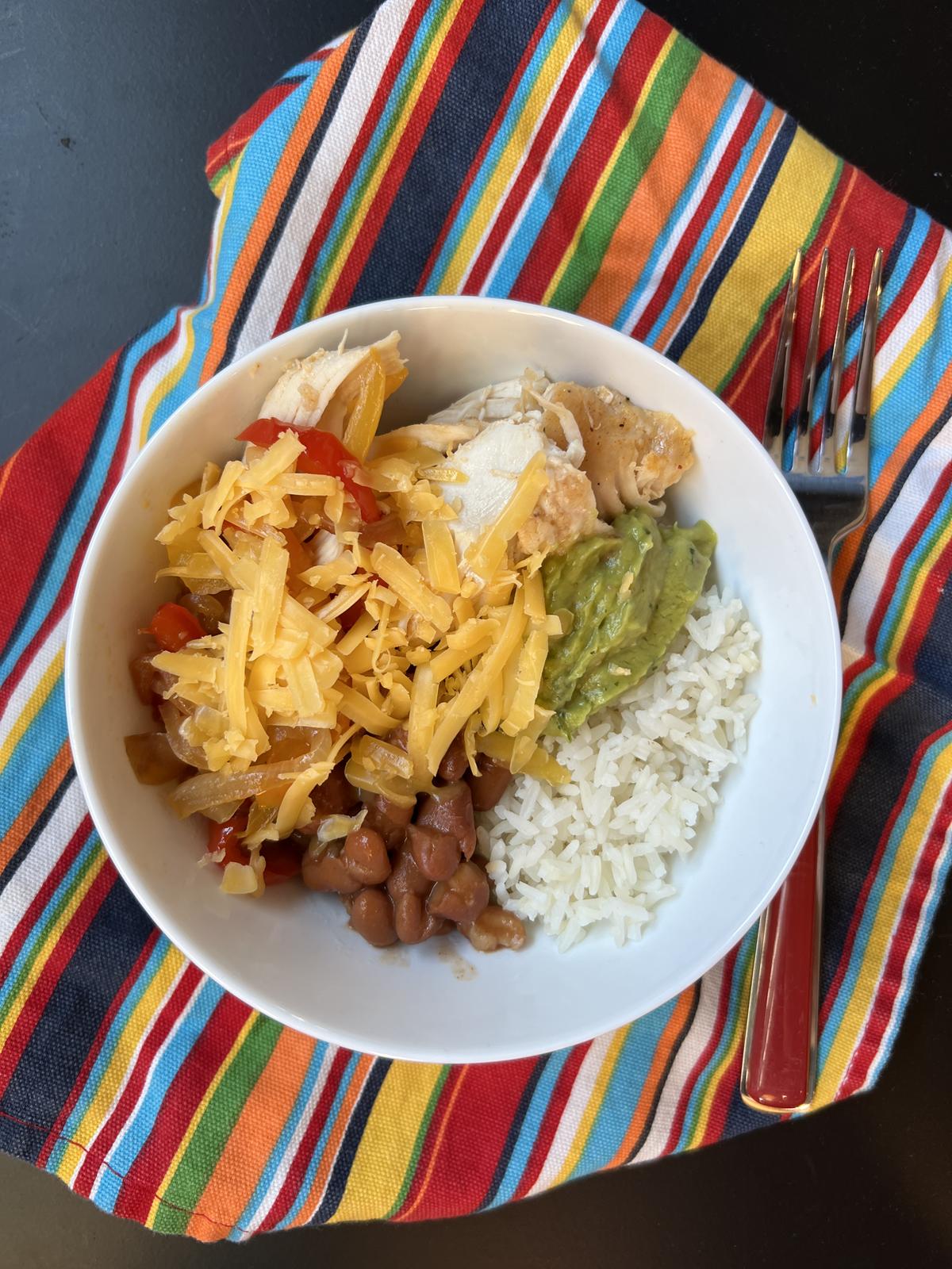 Mexican fajita bowl in white bowl on striped napkin