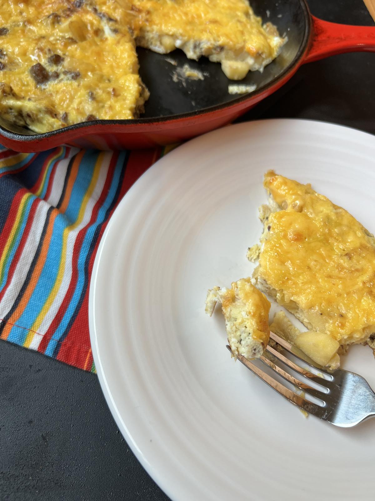 omelet on white plate with pan in background