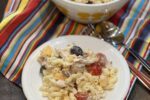 Chicken Bacon Ranch Pasta Salad in white and yellow bowl and on white plate on striped napkin