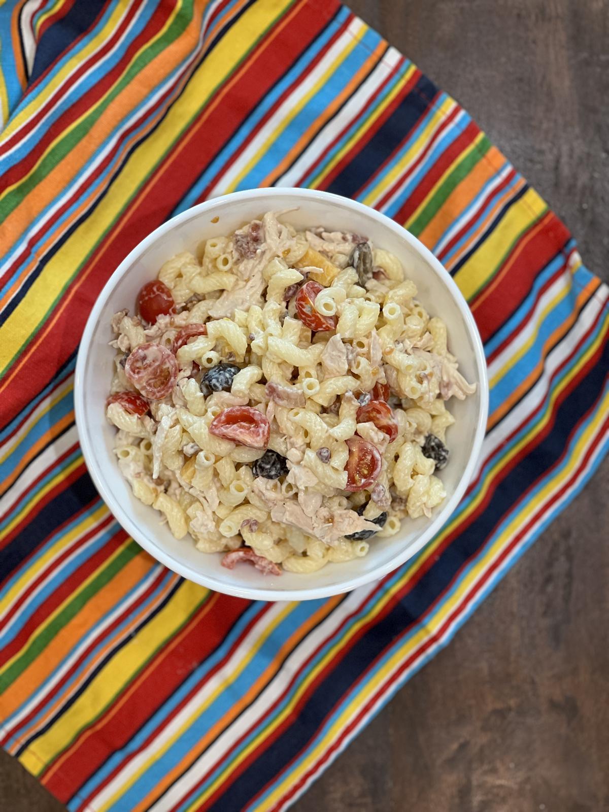 Chicken Bacon Ranch Pasta Salad Recipe in white bowl on striped napkin