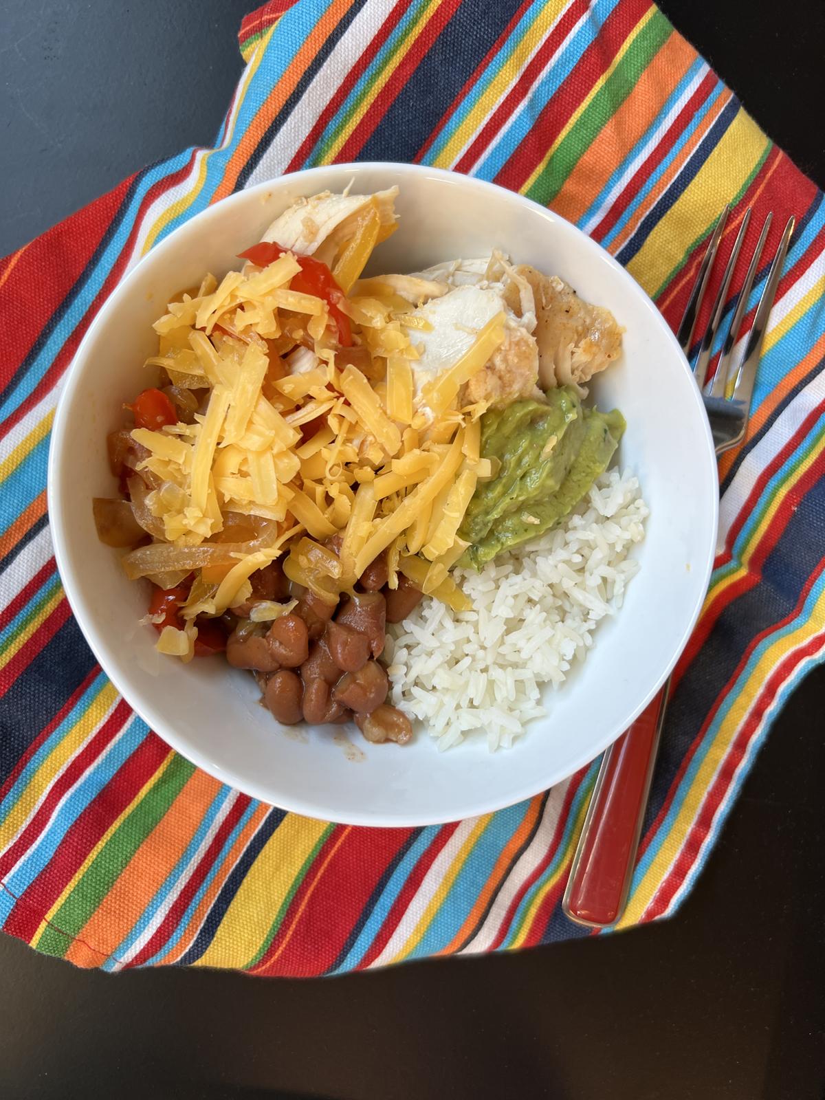 chicken fajita bowls in white bowl on striped napkin
