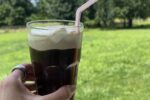 coca cola float in glass with cream and straw outside