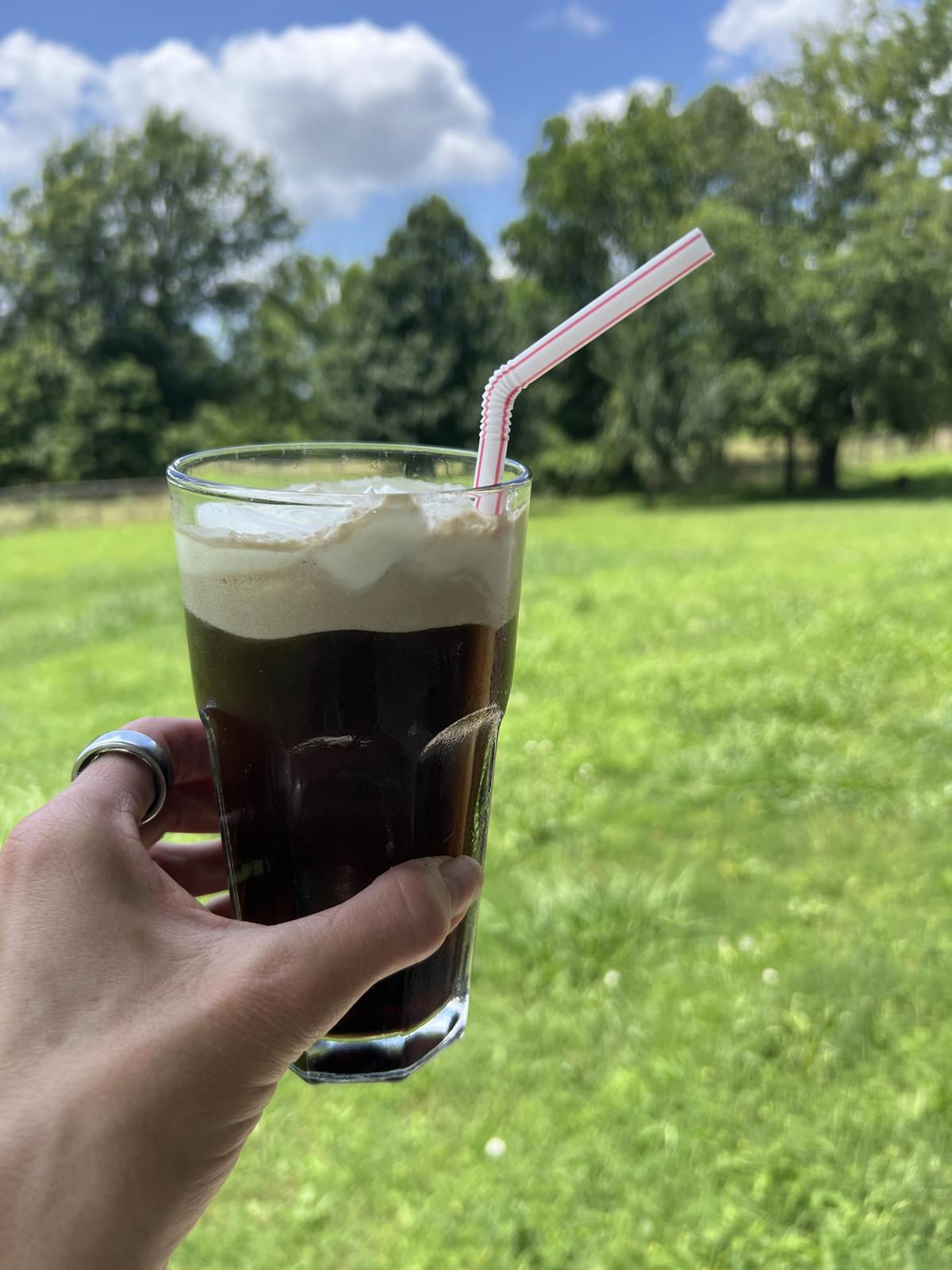 coca cola float in glass with cream and straw outside