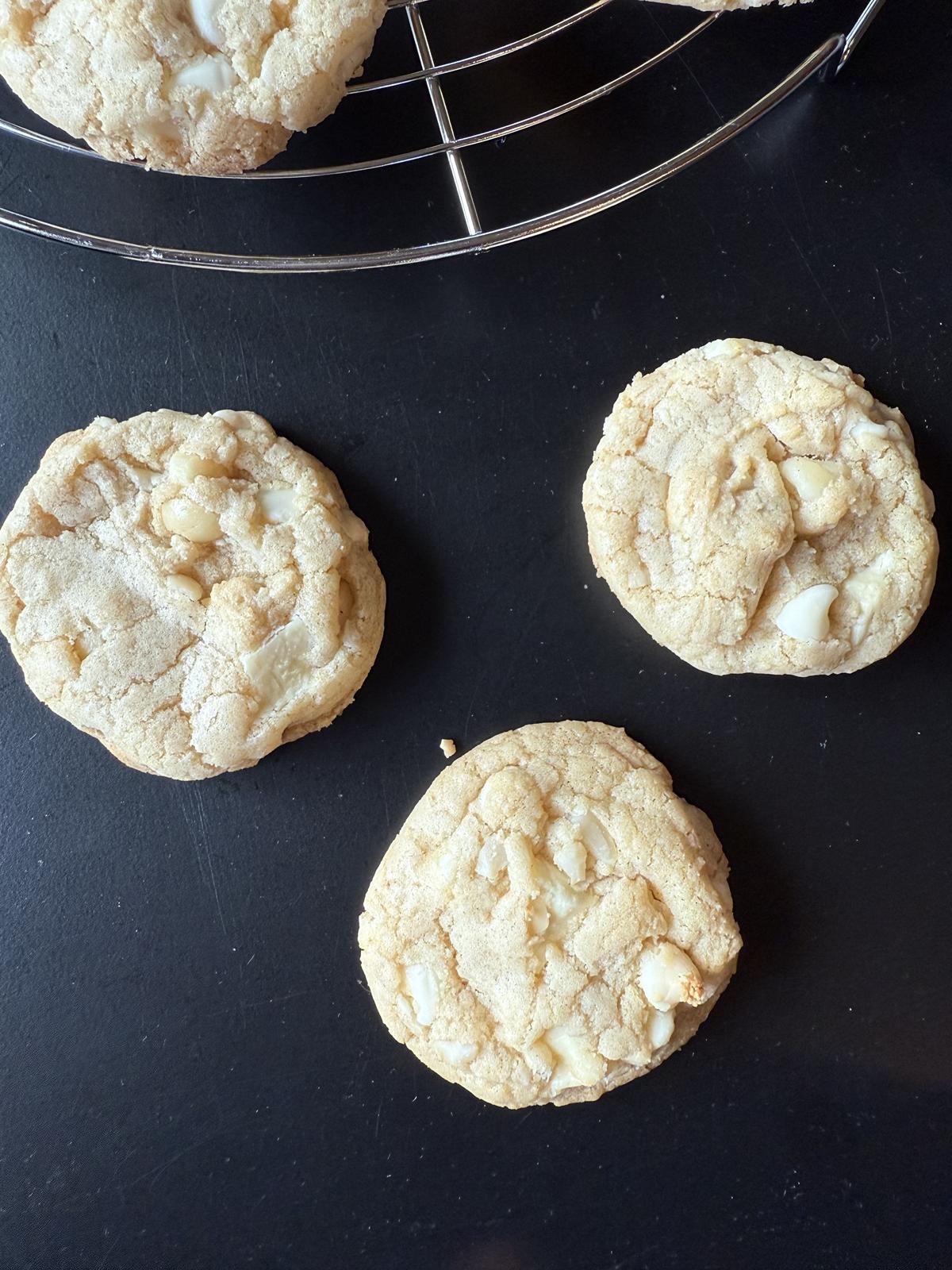 gluten free white chocolate macadamia nut cookies on black counter
