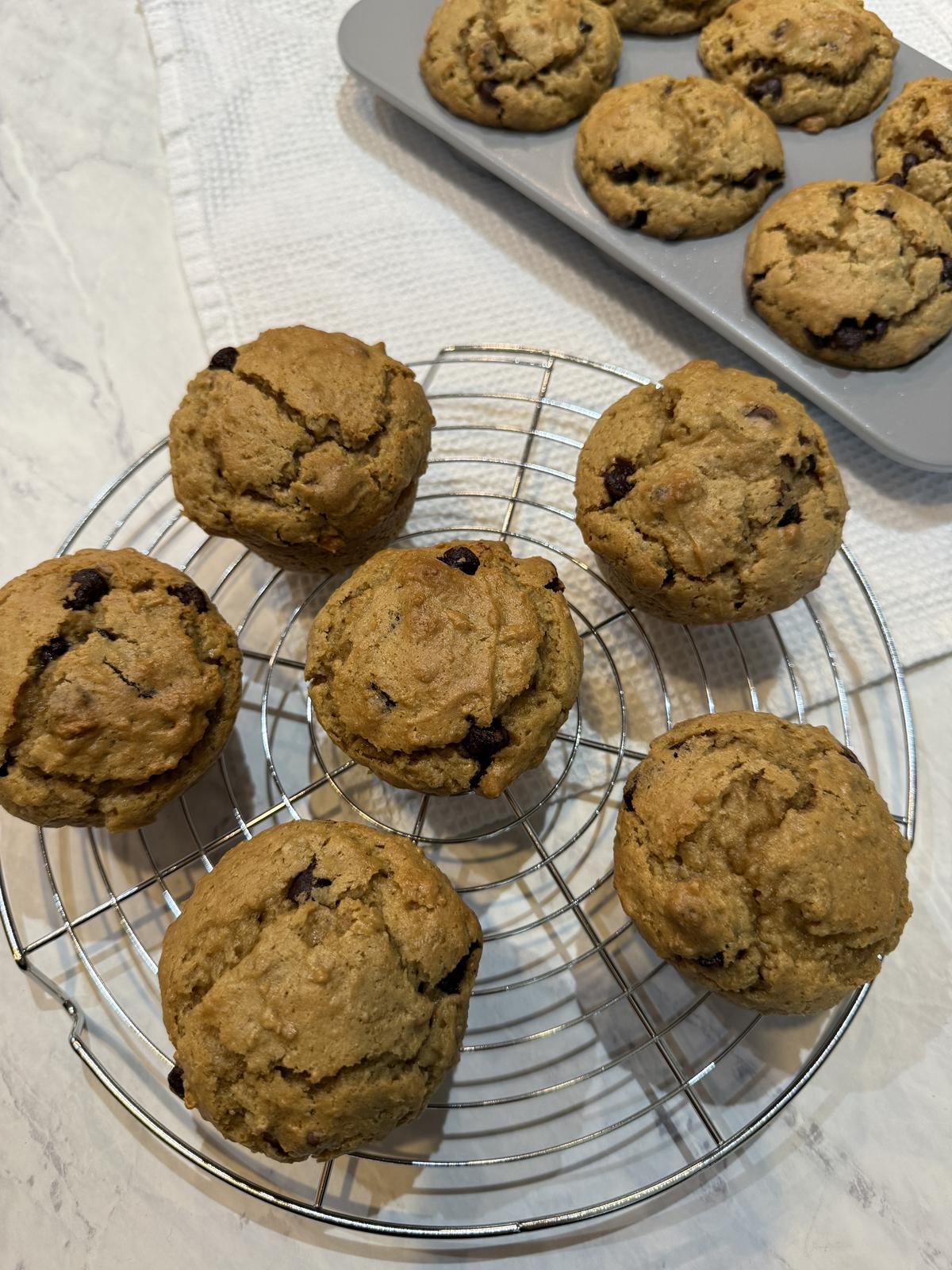 Leftover Oatmeal Peanut Butter Muffins with Chocolate Chips on cooling rack with muffin pan in background