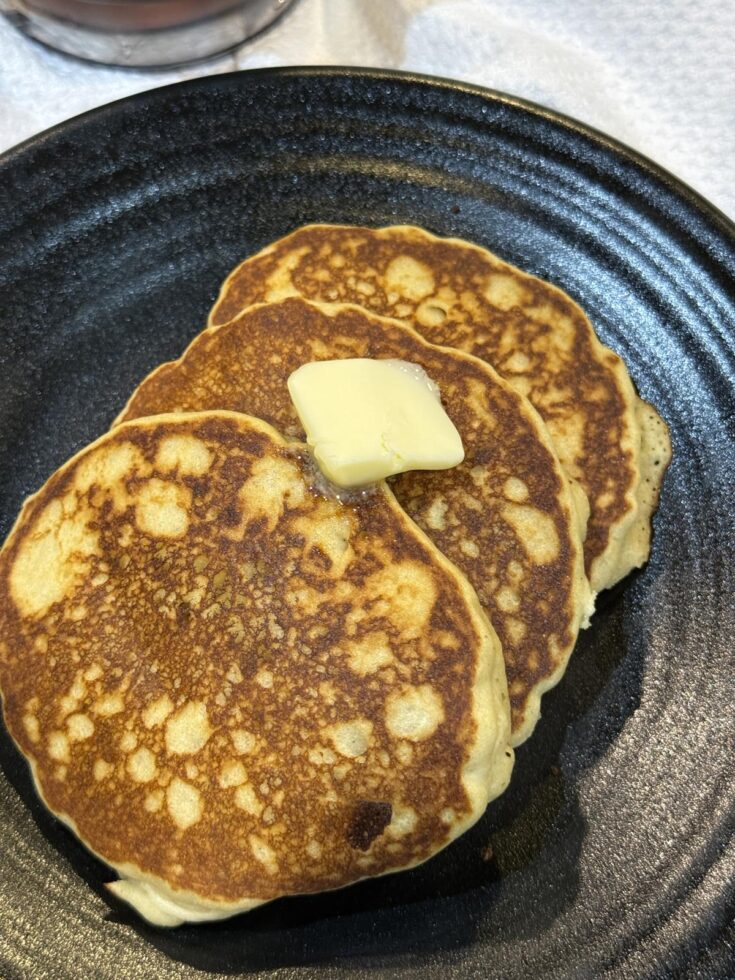 gluten free pancakes with butter on black plate