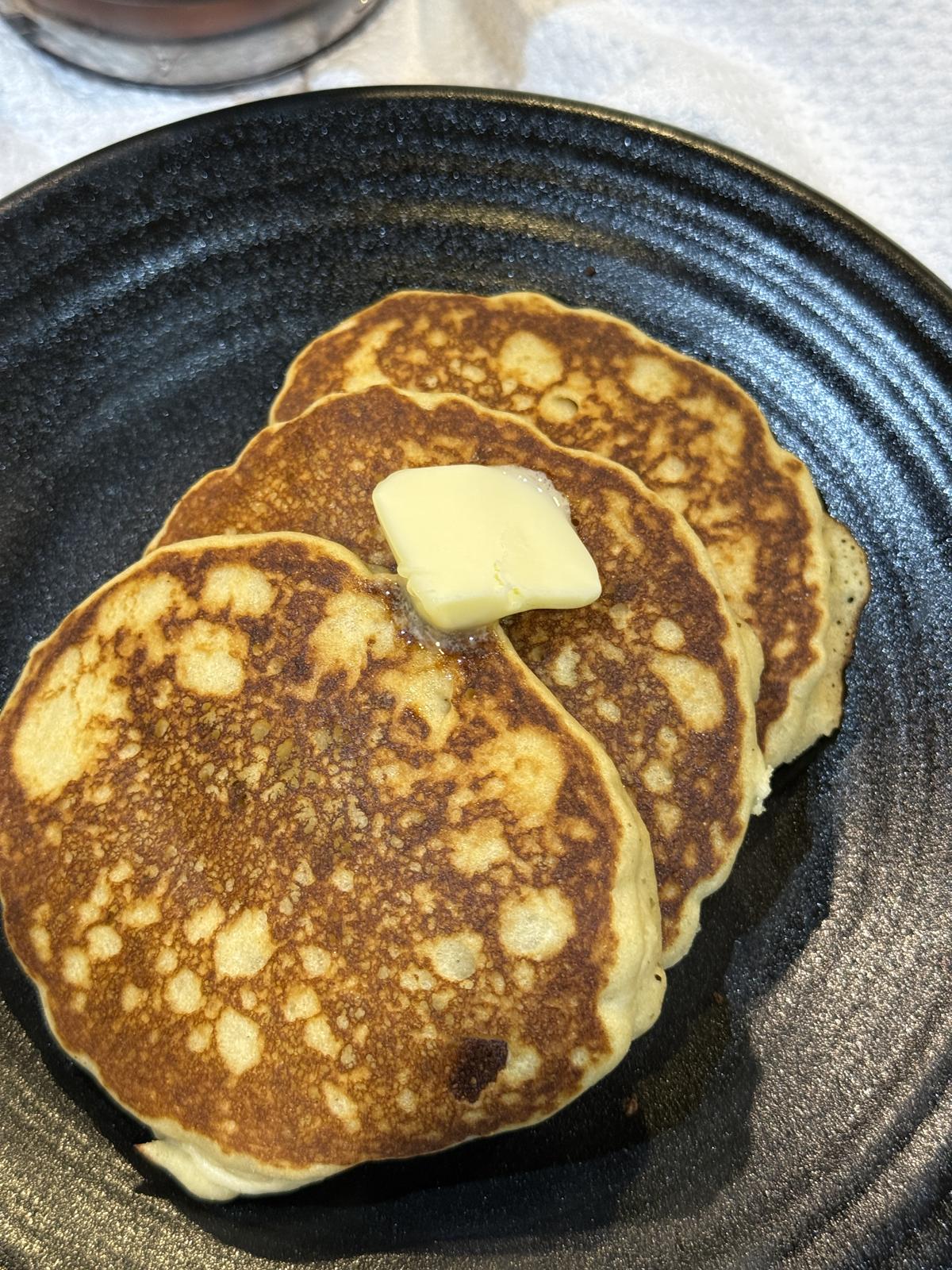 gluten free pancakes with butter on black plate