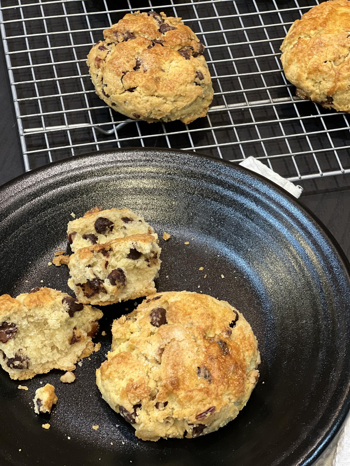 Ina Garten Chocolate Chip Pecan Scone on black plate with scones on cooling rack in background