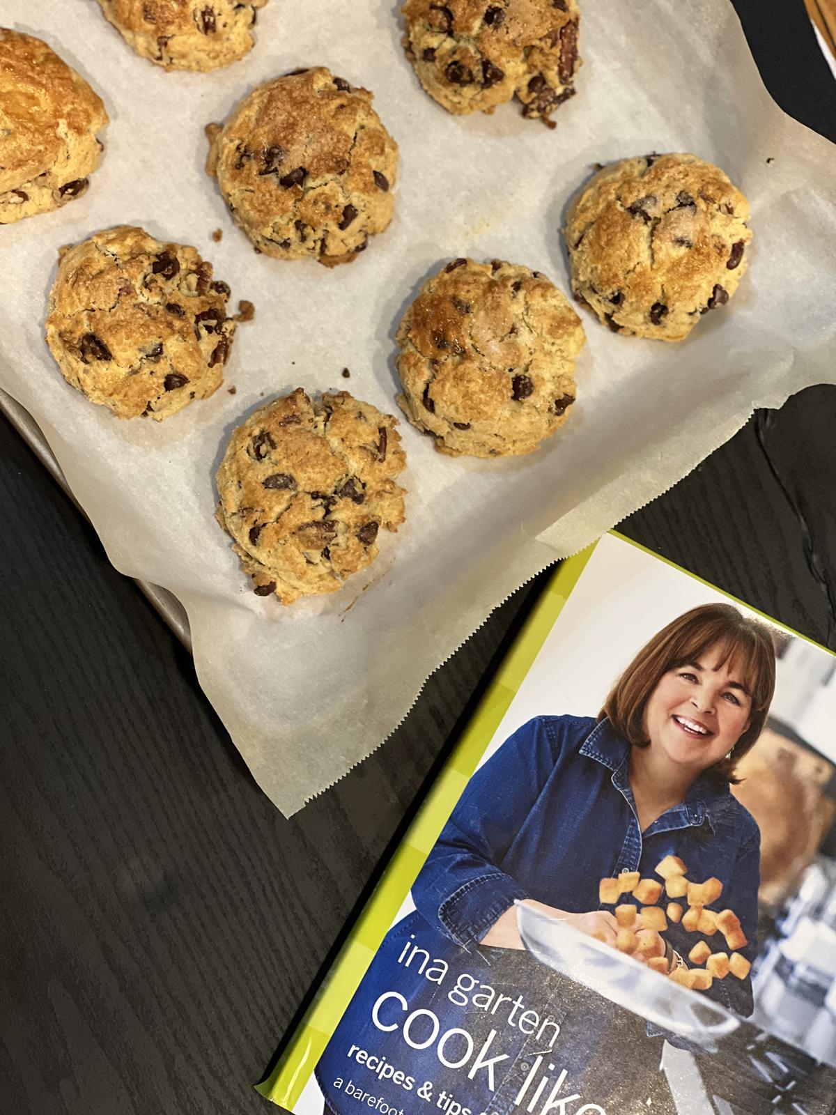 Ina Garten Cook Like a Pro cookbook with a pan of baked chocolate chip pecan scones in background