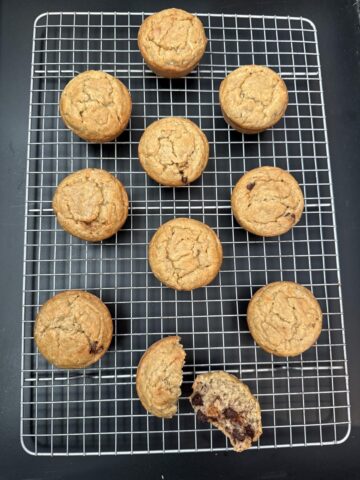 oatmeal banana muffins with chocolate chips on cooling rack with one muffin cut in half