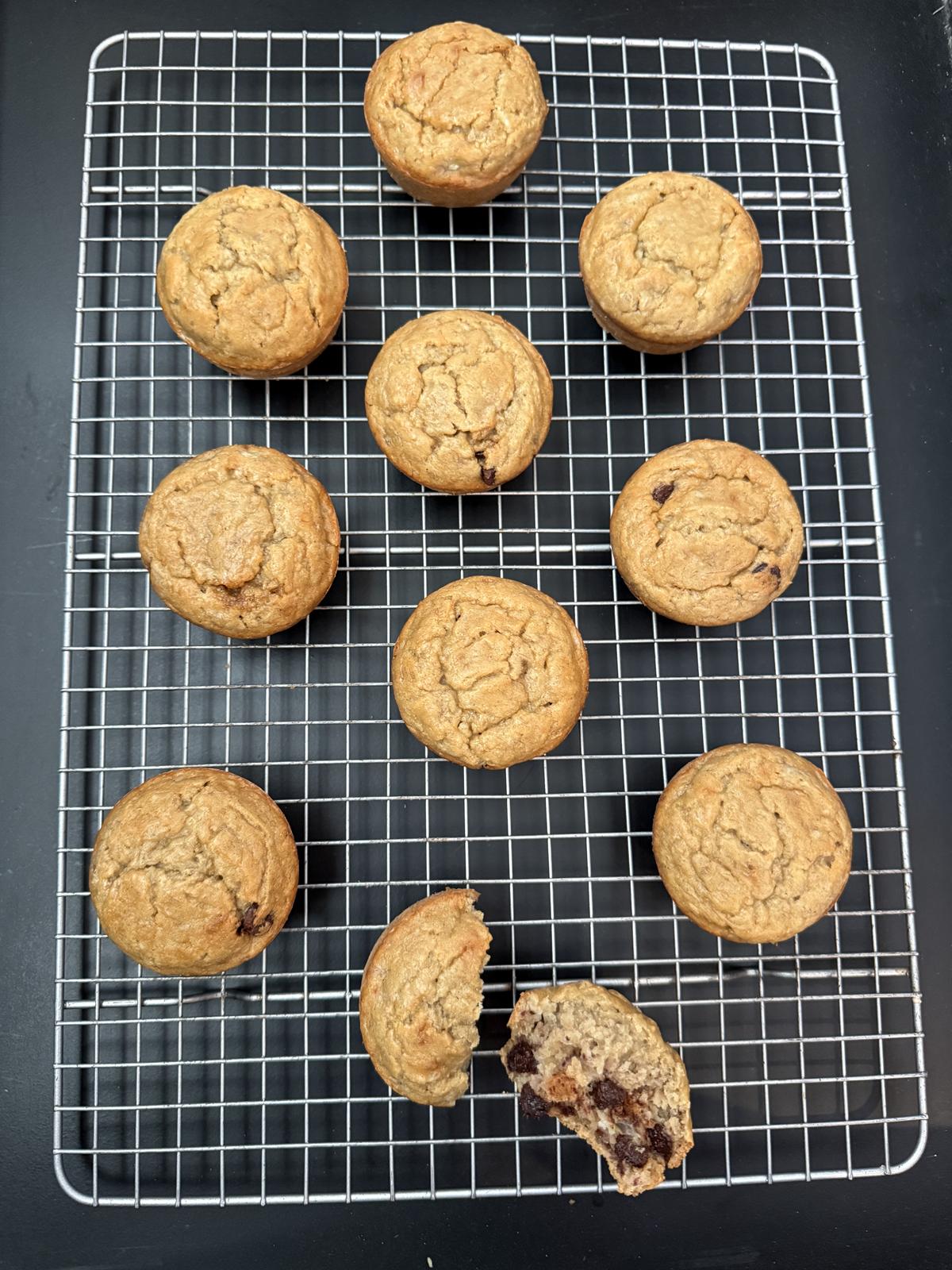 oatmeal banana muffins with chocolate chips on cooling rack with one muffin cut in half