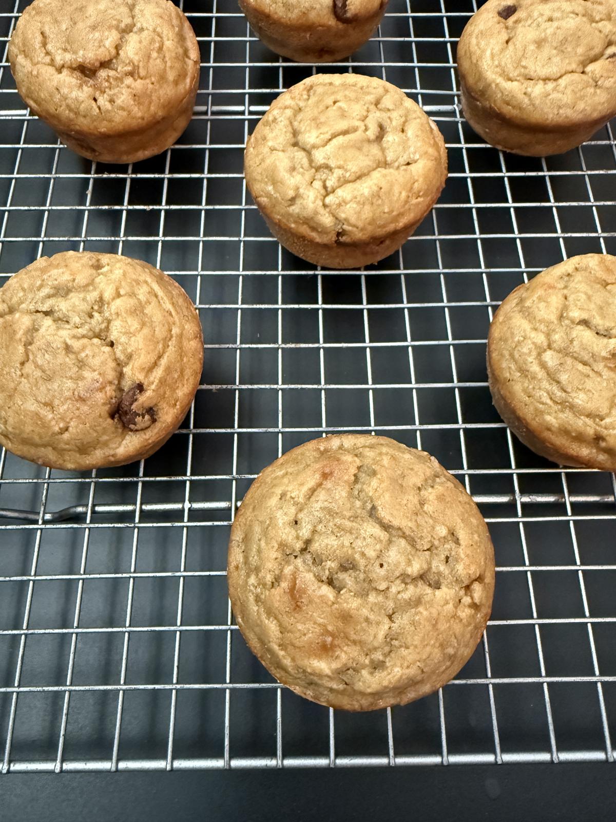 oatmeal banana muffins on cooling rack on black counter